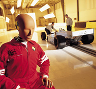 A test dummy is shown waiting to be placed in a race car for crash testing at CAPE.