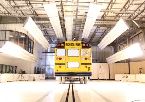 A school bus sits on CAPE's barrier block test track surrounded by lights.