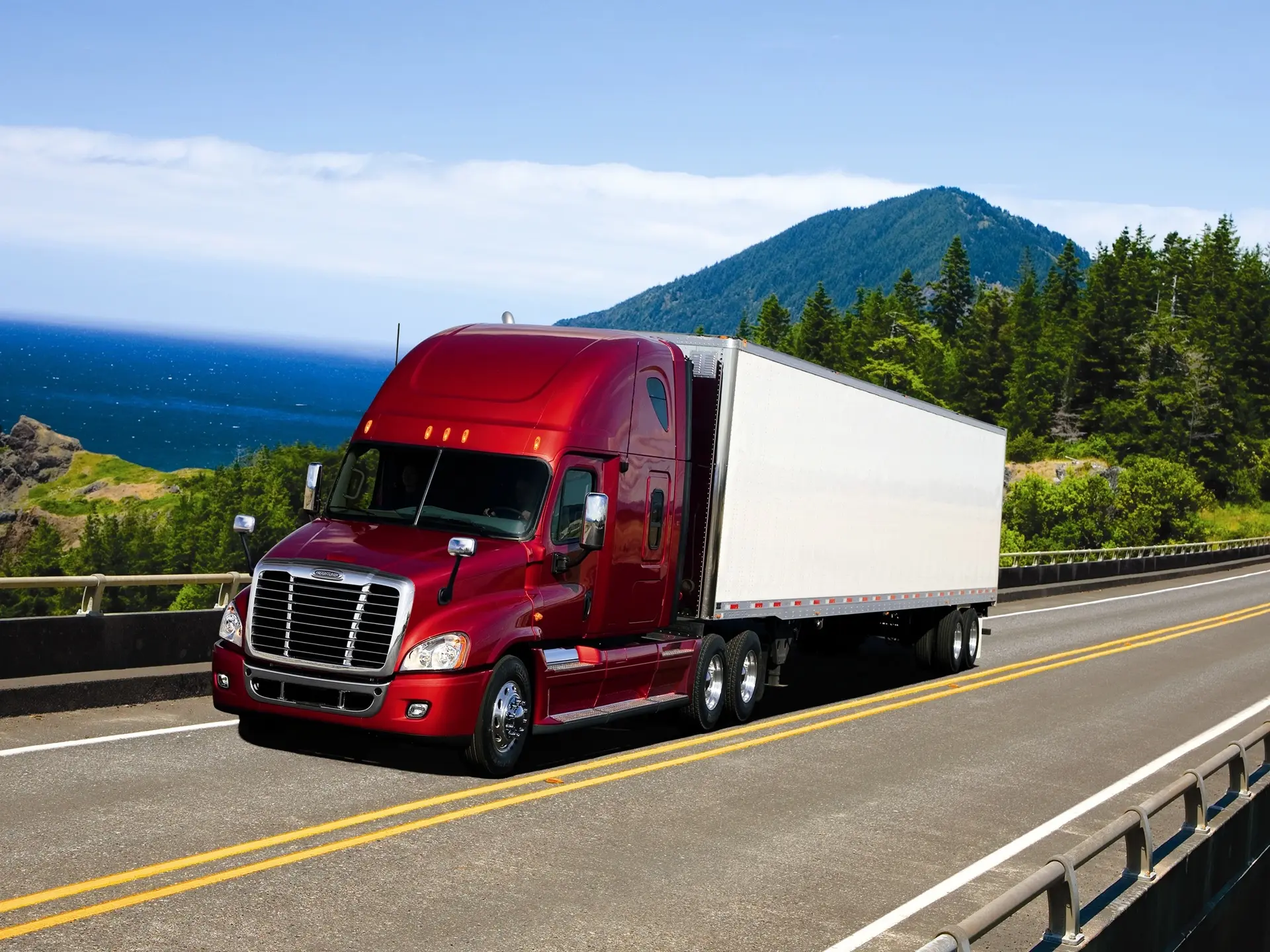 Red Freightliner semi-truck hauling a white trailer on a road