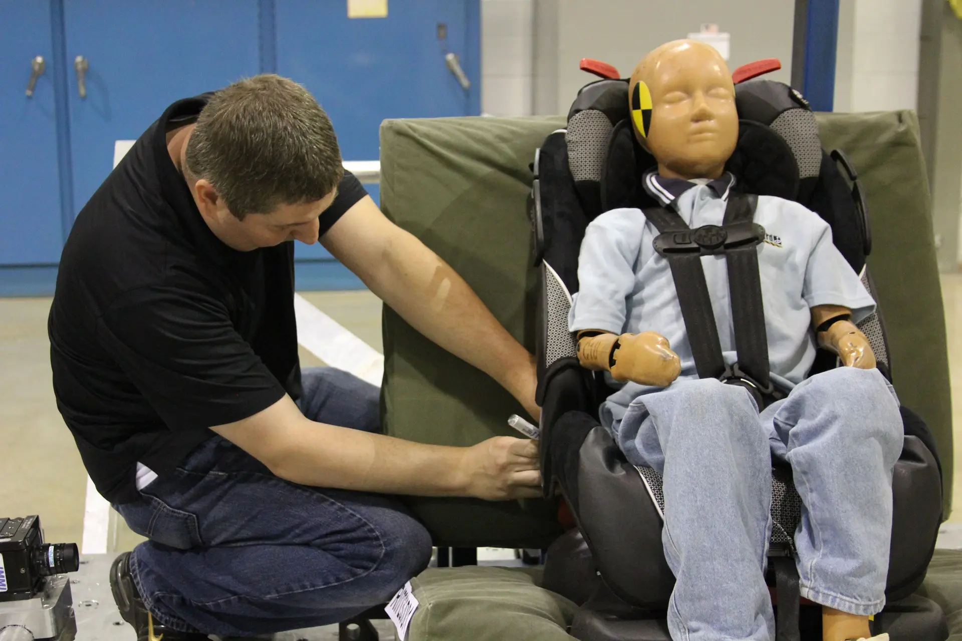 Technician preparing a child safety seat for testing